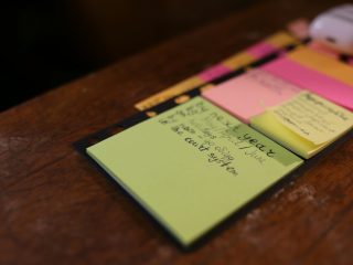 green sticky note on brown surface