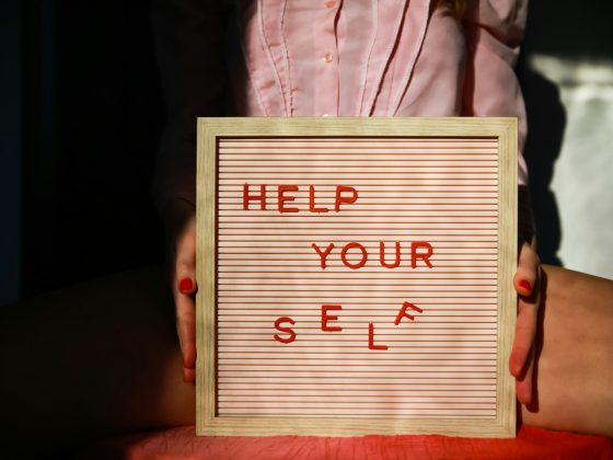 a person holding a sign that says help your self