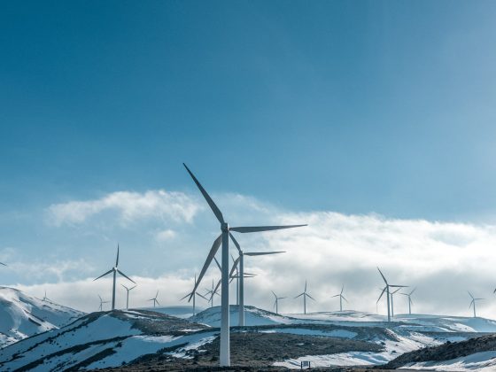 wind turbines on snowy mountain under clear blue sky during daytime