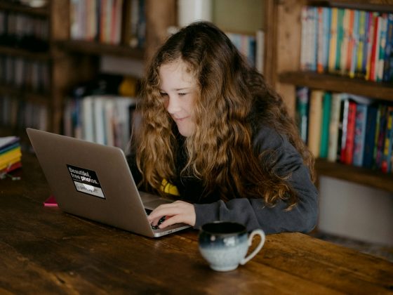 woman in black jacket using macbook pro